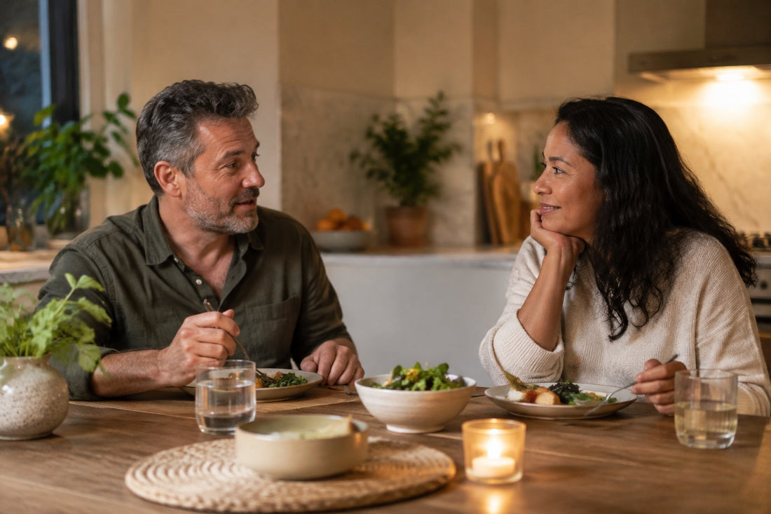 A couple eating a simple dinner at a kitchen table and talking